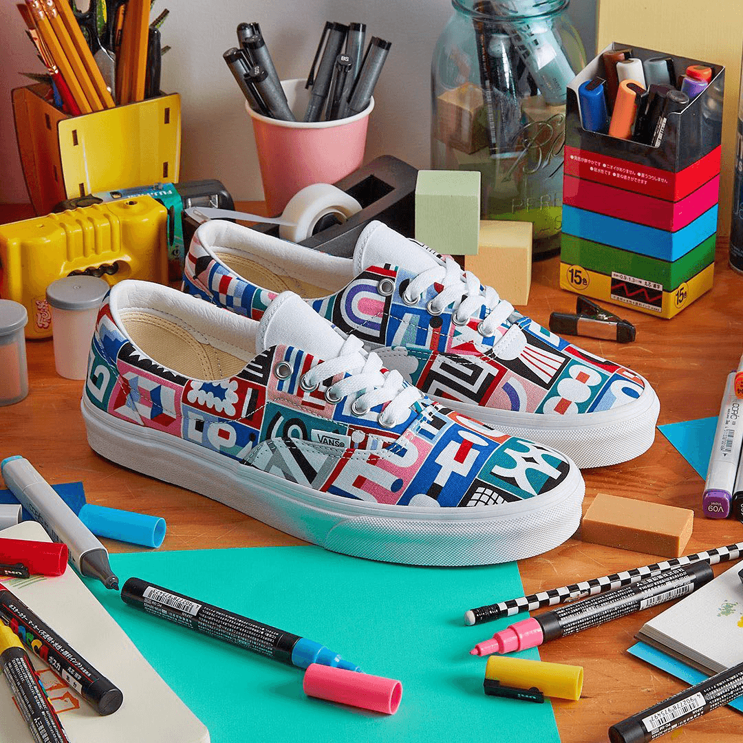 A pair of Vans shoes, colorful markers, sketchbooks and creative objects on a table. Example of Geometric pattern design of vans shoes by Marc David Spengler